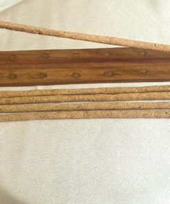 Varillas de incienso Palo Santo en porta incienso de madera sobre tela blanca