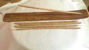 Varillas de incienso Palo Santo en porta incienso de madera sobre tela blanca