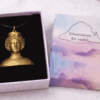 Colgante de la diosa Tanit, con diseño de busto clásico, presentado en caja de regalo sobre fondo blanco