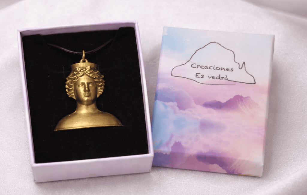 Colgante de la diosa Tanit, con diseño de busto clásico, presentado en caja de regalo sobre fondo blanco