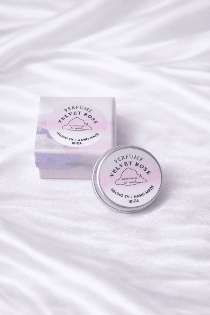 Perfume sólido Velvet Rose hecho a mano en Ibiza, presentado en caja pastel y envase metálico sobre fondo blanco de seda