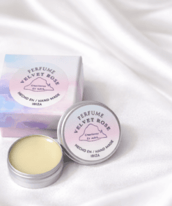 Perfume sólido Velvet Rose hecho a mano en Ibiza, presentado en caja pastel y envase metálico sobre fondo blanco de seda